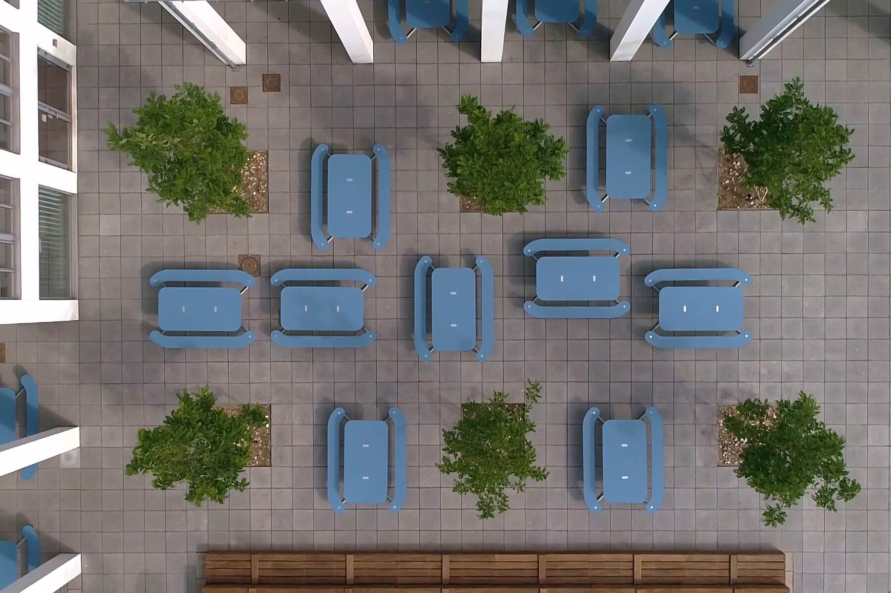 Otte blå Plateau Picnic I borde i række blandt 6 store, grønne træer i Nordhavn