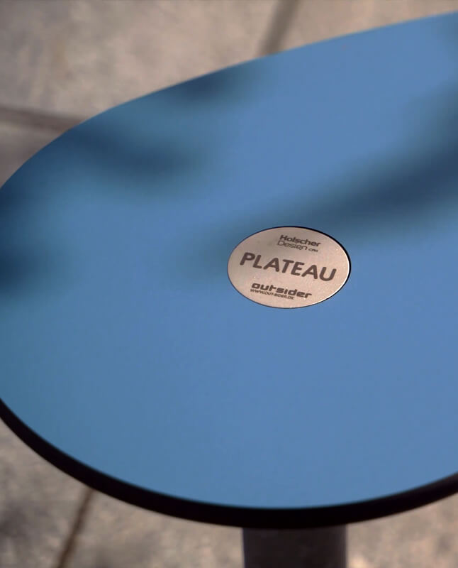 Et nærbillede af et blåt plateau picnic I bord, hvor man kan se brandlogo