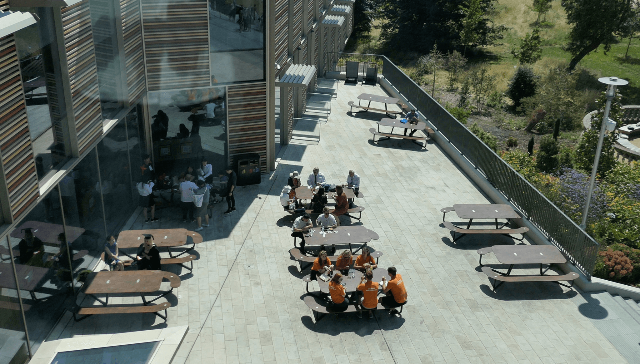 Ni brune Plateau Picnic L bordbænkesæt fyldt med elever fra Royal Holloway University i England