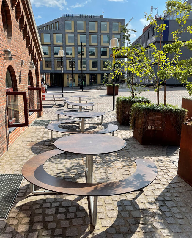 Tre brune Plateau Picnic Round bordbænkesæt ved en plads