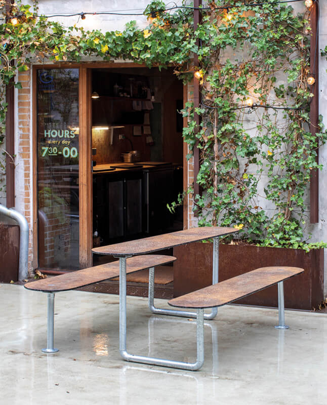 Et brunt Plateau Picnic bordbænkeset ude foran en cafe