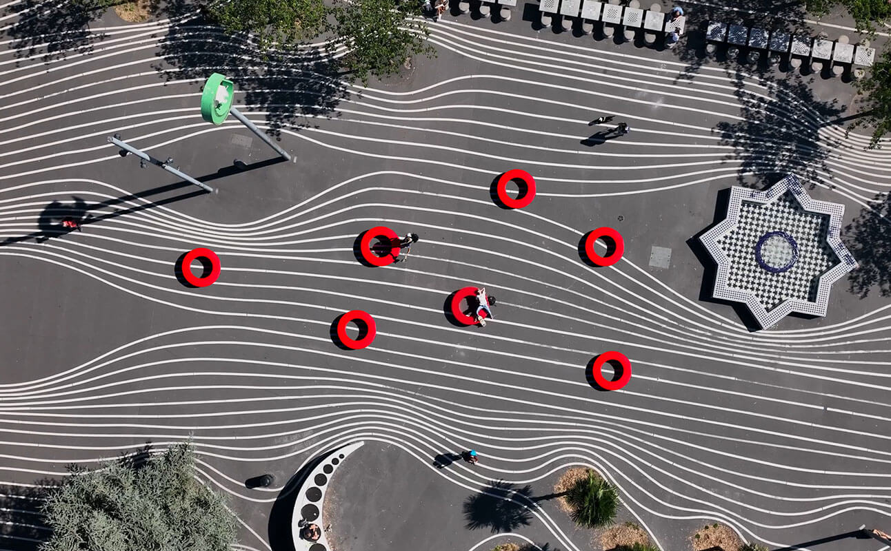 Syv røde Loop Circle set oppefra på en plads på Nørrebro