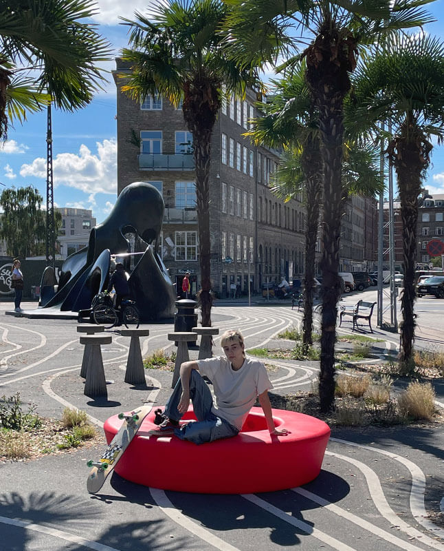 En skater tager en pause på en rød Loop Circle på den sorte plads på Nørrebro