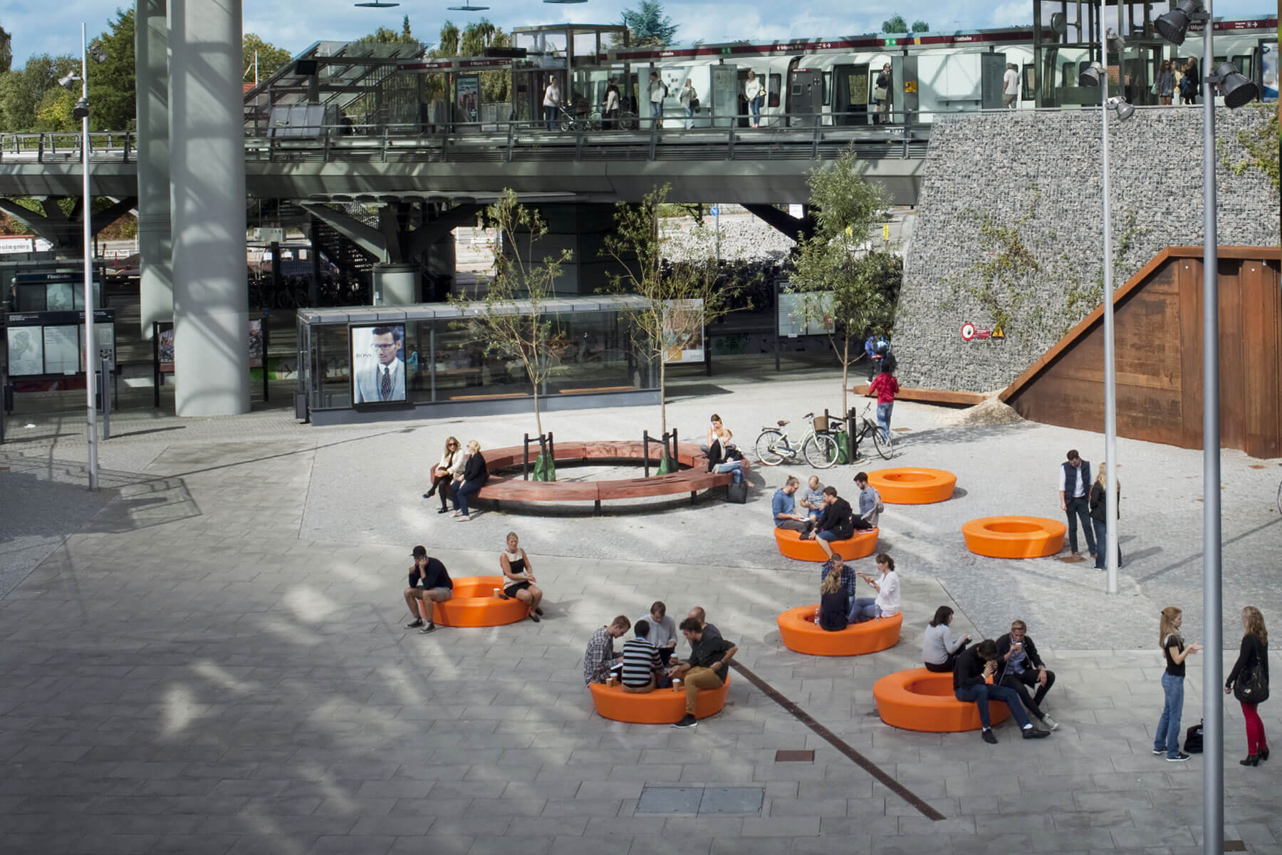 Syv orange Loop Circle bænke på Flintholm St besat af en masse studerende fra CBS