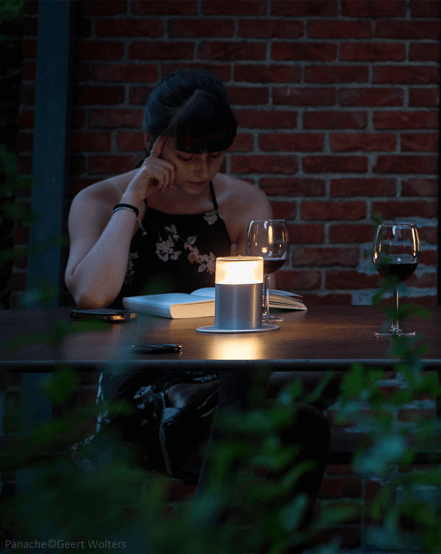 Et nærbillede af en kvinde, der læser i mørkets skær belyst med Plateau Point Sun